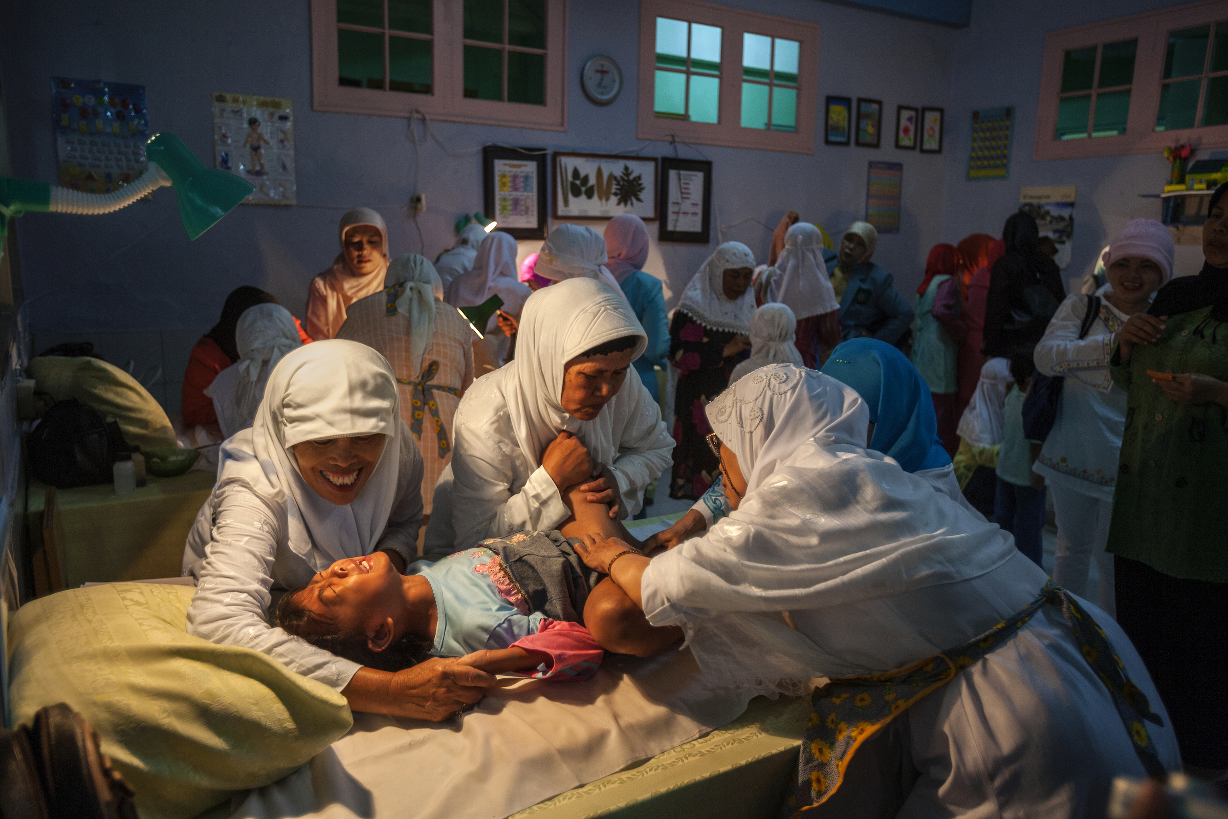A young girl screams while being circumcised in Bandung, Indonesia.
